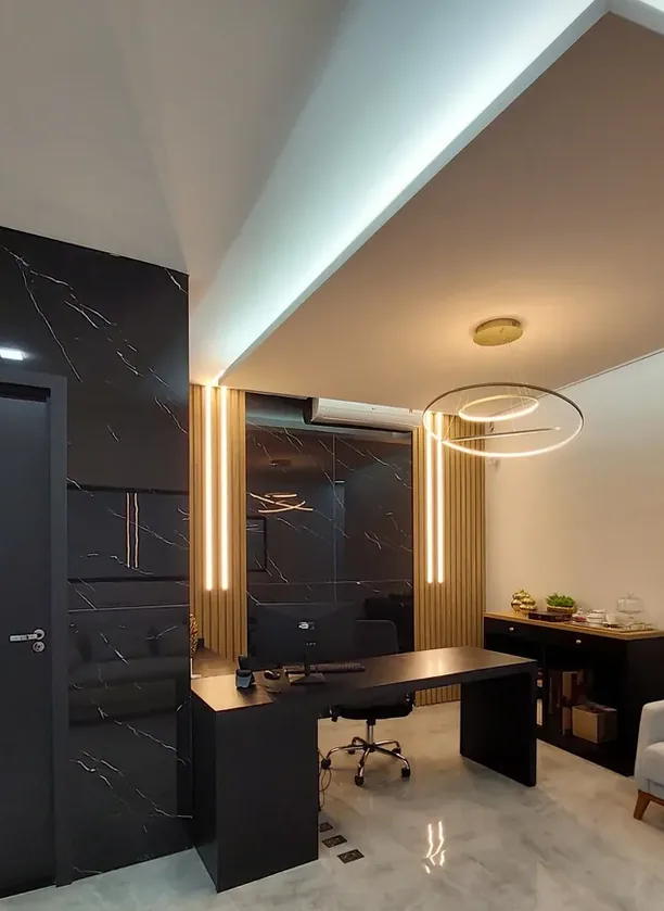 Sala de diretoria com mesa preta, painéis marmorizados escuros, ripado amadeirado com fitas de LED e aparador