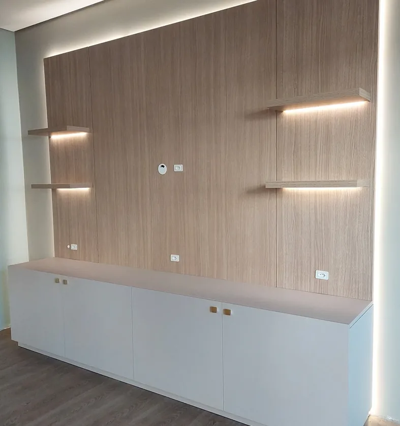 Painel de TV amadeirado com prateleiras flutuantes iluminadas por LED, iluminação perimetral e rack branco